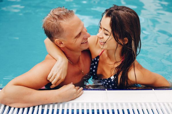 elegant-couple-swim-in-the-pool-XNWHKDR-768x512